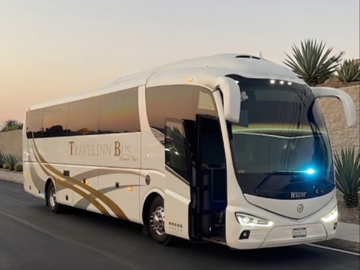 Autobús TRAVELINN Bus al atardecer, de tres cuartos frontal, con el rótulo dorado Diamond Class y la puerta abierta